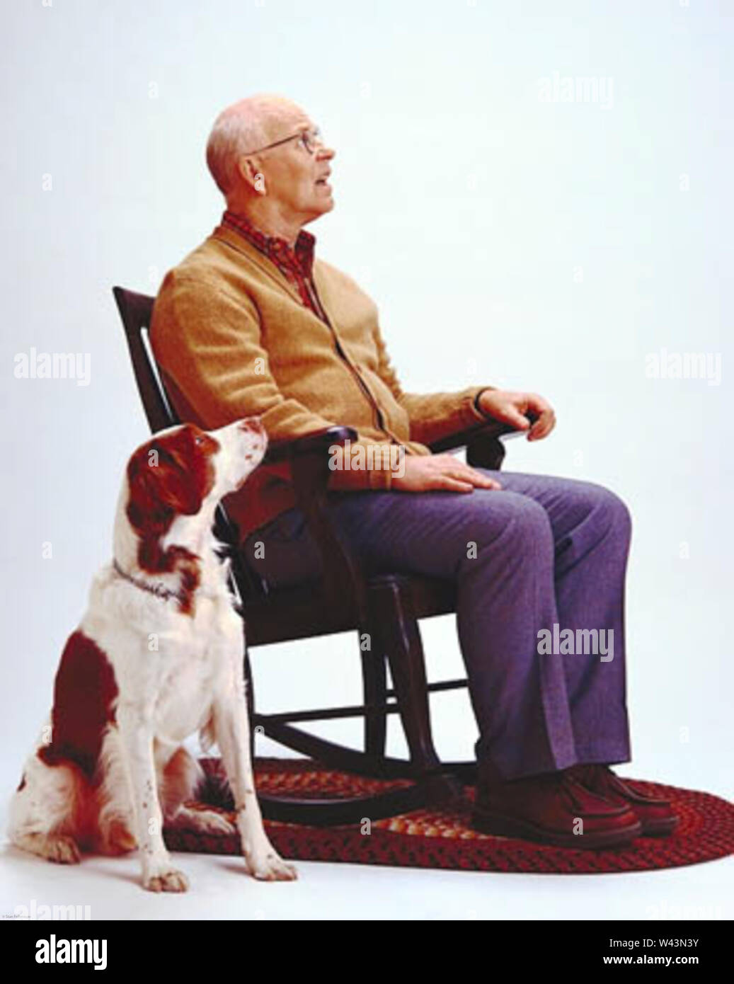 Ältere Mann da oben sitzen, mit Blick auf den Himmel mit einem Retriever auch suchen Stockfoto