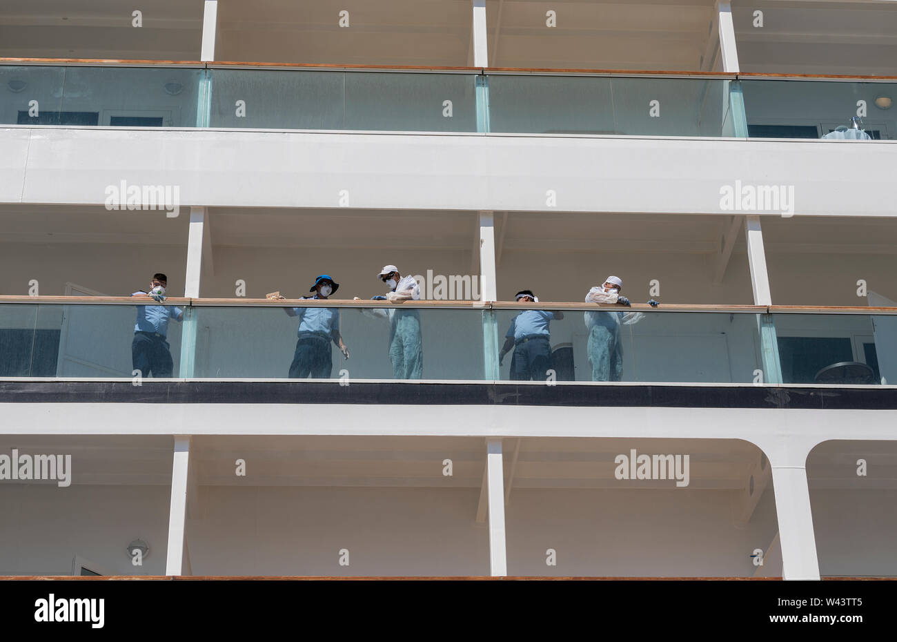 Montevideo: Juli 19; Männer arbeiten auf Holz- schiene Balkon mit schützenden arbeiten Masken in Cruiser Schiff Seabourn Odyssey. Ermoupolis 19 Juli 2019 Griechenland. Stockfoto