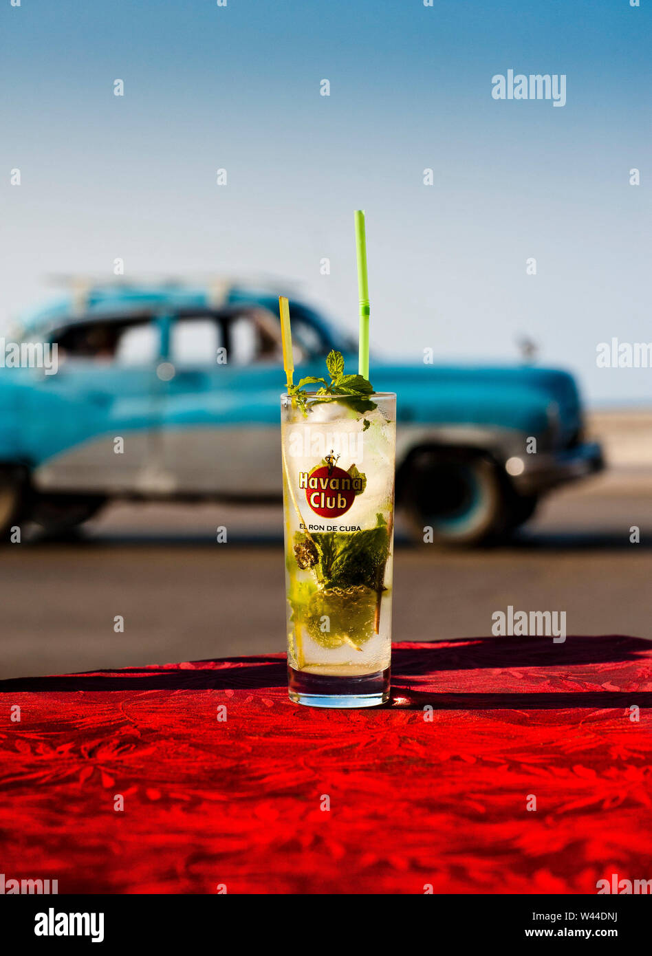 Einen Mojito auf einem Tisch in Havanna Kuba als klassische Kubanische Auto fährt durch Stockfoto