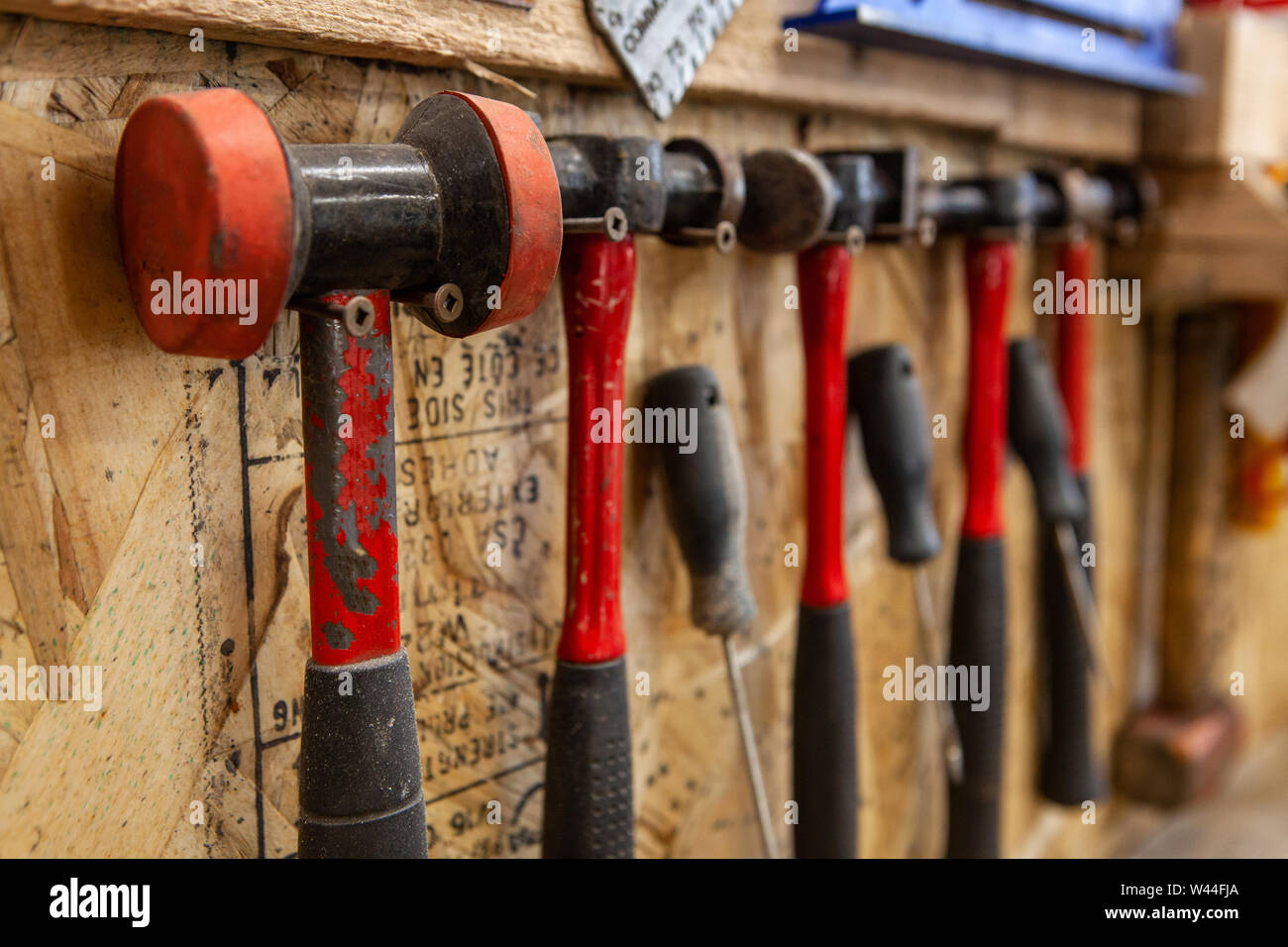Eine Detailansicht auf einer Vielzahl von metallarbeiten Hammer und  Schlägel in einem Workshop. Verschiedene Größen und Stile hängen an  Schrauben für einfachen Zugang Stockfotografie - Alamy