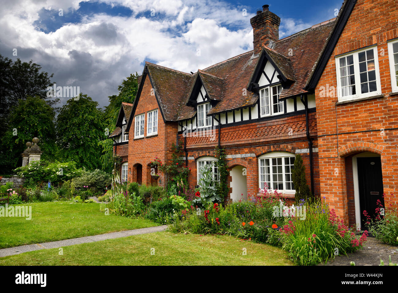 Aus rotem Backstein im Tudor Stil Gebäude mit Blumengarten der Fowlers Cottage an der High Street Avebury Wiltshire England Stockfoto