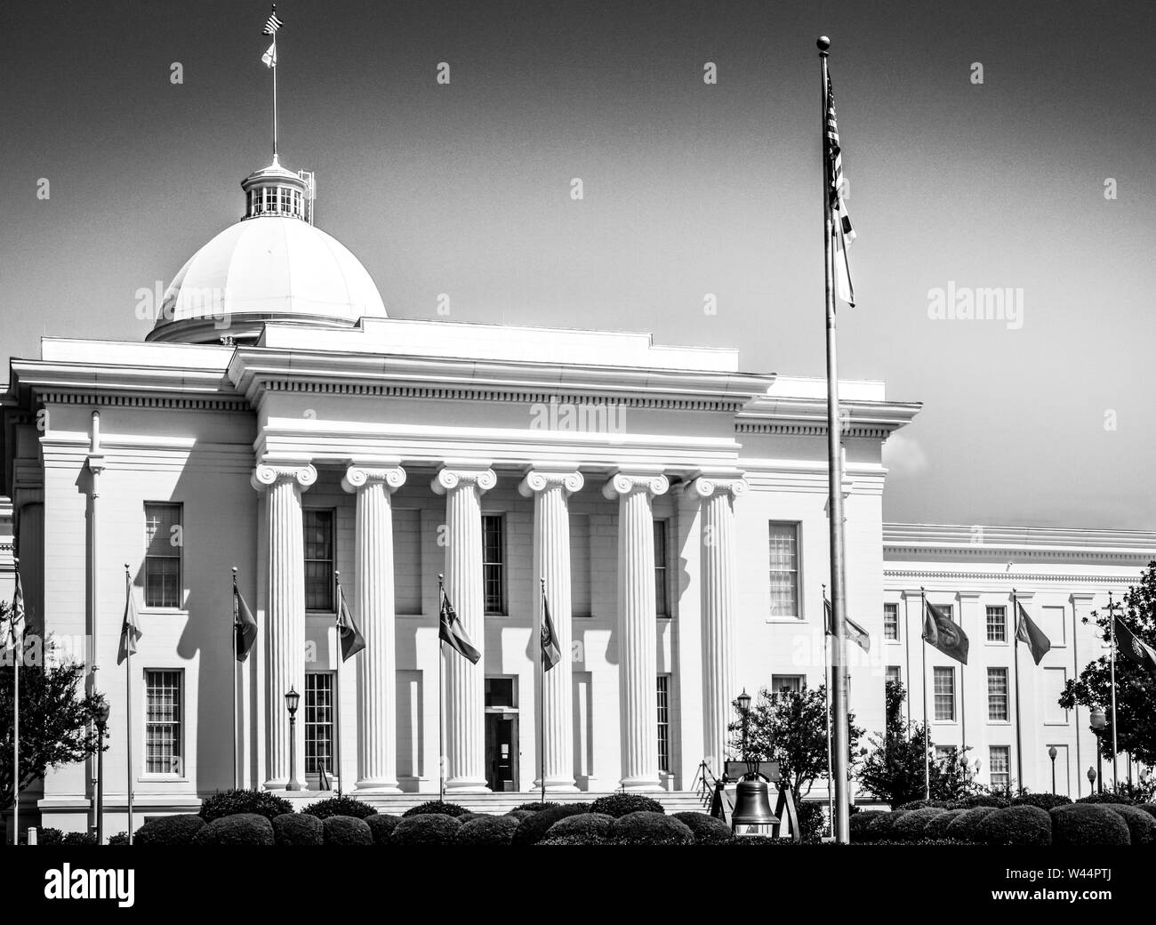 Die Allee der Fahnen und eine Nachbildung der Liberty Bell, bevor die historischen Alabama State Capitol Building in Montgomery, AL Stockfoto