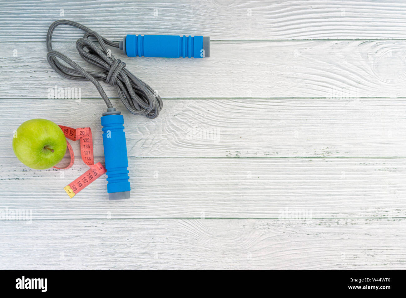 Top oder flach auf Apple Obst und Springseil mit Kopie Raum auf Holz- Hintergrund. Gesundes Konzept. Selektive konzentrieren. Stockfoto