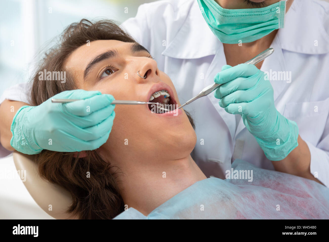 Dunkelhaarige brown-eyed Teenager in einem Zahnarztstuhl liegen Stockfoto