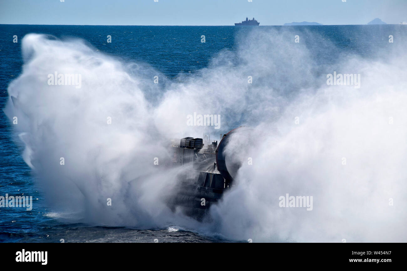 190717-N-RI 884-1081 CORAL SEA (17. Juli 2019) Landing Craft, Luftkissen (LCAC) 8 beendet das gut Deck des Amphibious Assault ship USS Wasp (LHD 1) Während die amphibious Transport dock Schiff USS Green Bay (LPD 20) Transite vor der Küste im Norden von Australien. Wasp, Flaggschiff der Wasp Expeditionary Strike Group, mit 31 Marine Expeditionary Unit begonnen, nimmt derzeit an Talisman Sabre 2019 vor der Küste im Norden von Australien. Eine bilaterale, Biennale, Talisman Säbel ist konzipiert nach den US-amerikanischen und australischen Combat Training, Bereitschaft und Interoperabilität durch realistische verbessern Stockfoto