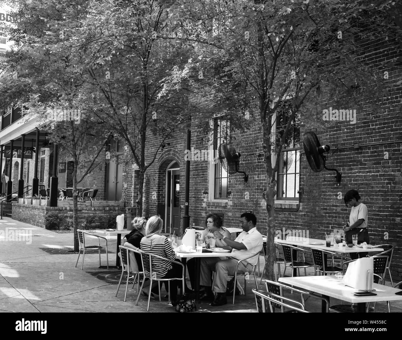 Die Menschen genießen Sie eine Mahlzeit im Freien zusammen im modernen Restaurant und neu belebt, in "Die Gasse in der Innenstadt von Montgomery, AL, B&W entfernt Stockfoto