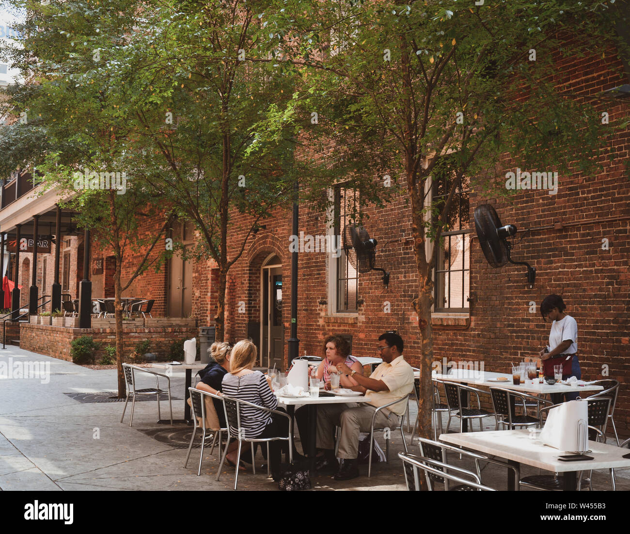Die Menschen genießen Sie eine Mahlzeit im Freien zusammen im modernen Restaurant und neu belebt, in "Die Gasse in der Innenstadt von Montgomery, AL, Stockfoto