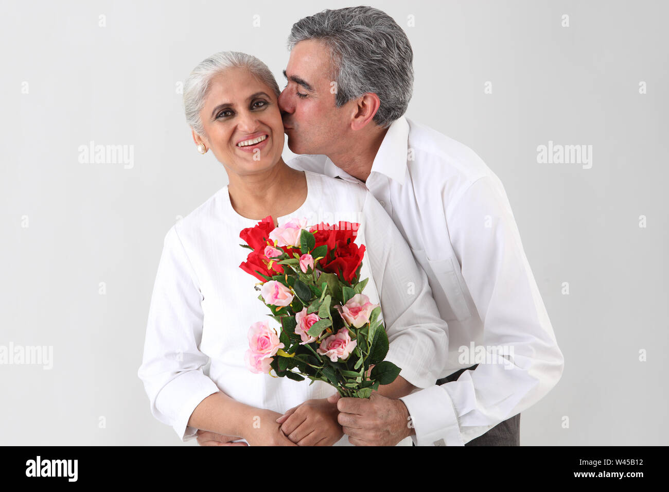 Mann küsst seine Frau Stockfoto