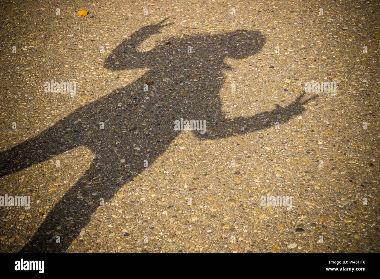 Schatten der eine stehende Frau mit zwei Arme und Finger nach oben Stockfoto