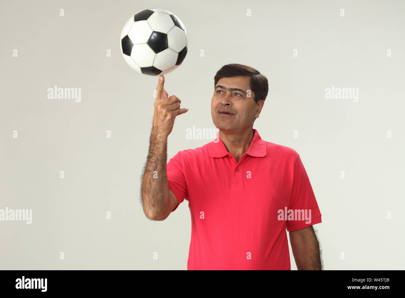 Mann balanciert einen Fußball auf dem Finger Stockfoto