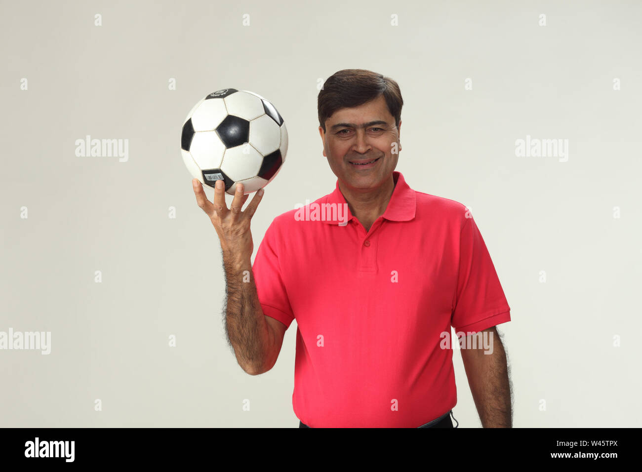 Porträt eines Mannes hält einen Fußball und lächelnd Stockfoto