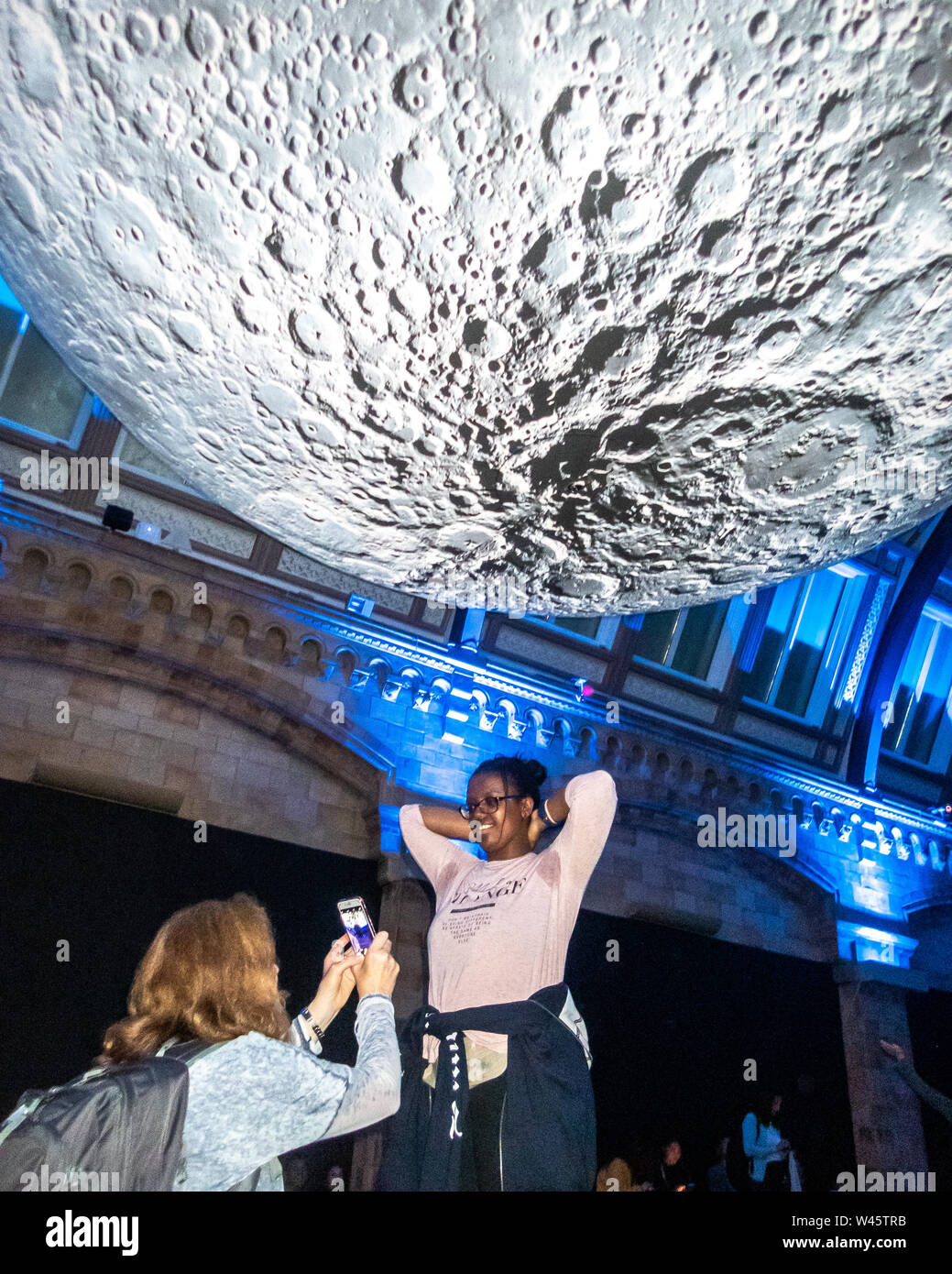 London, Großbritannien, 19. Juli 2019. Die Besucher des Natural History Museum stellen neben einem Modell des Mondes. Der lunar Ausstellung war besonders Bevölkerung Stockfoto