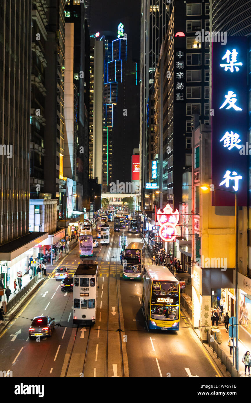 Hongkong, China - Macrh 15 2019: Straßenbahnen, Busse und Autos fahren im Herzen von Hong Kong Island Central Business District in der Nacht. Stockfoto