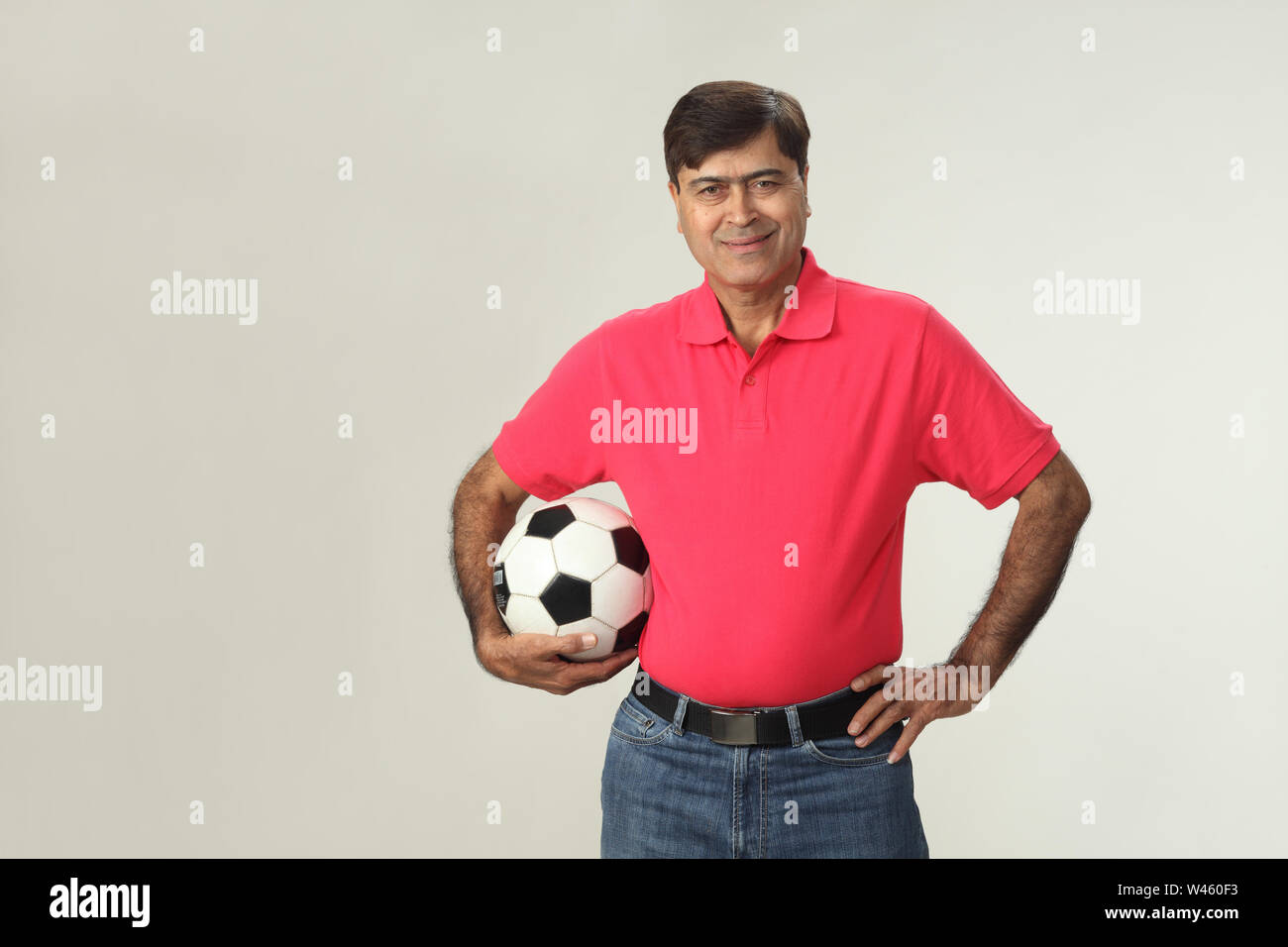 Porträt eines Mannes hält einen Fußball und lächelnd Stockfoto
