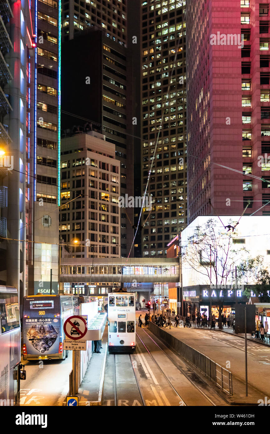 Hongkong, China - Macrh 15 2019: Straßenbahnen, Busse und Autos fahren auf der Insel Hong Kong Central Business District in der Nacht entlang der Luxus Des Voeux Roa Stockfoto