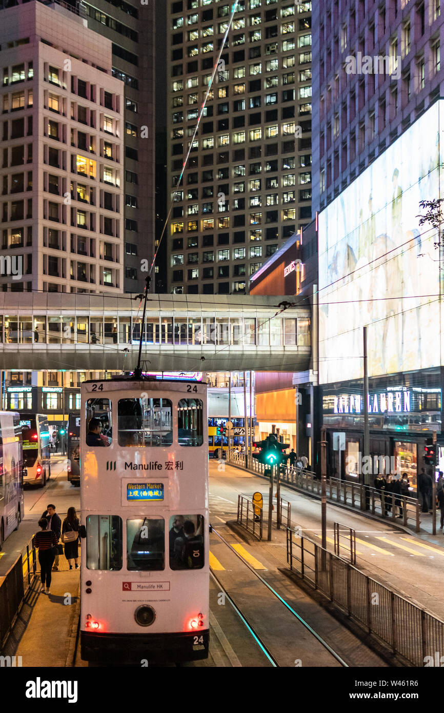 Hongkong, China - Macrh 15 2019: Straßenbahnen, Busse und Autos fahren auf der Insel Hong Kong Central Business District in der Nacht entlang der Luxus Des Voeux Roa Stockfoto
