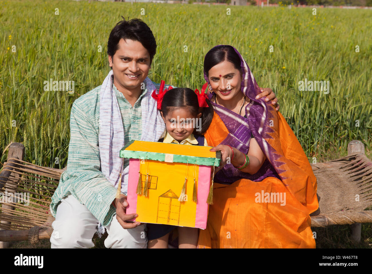 Familie zeigt Traumhaus und lächelt Stockfoto