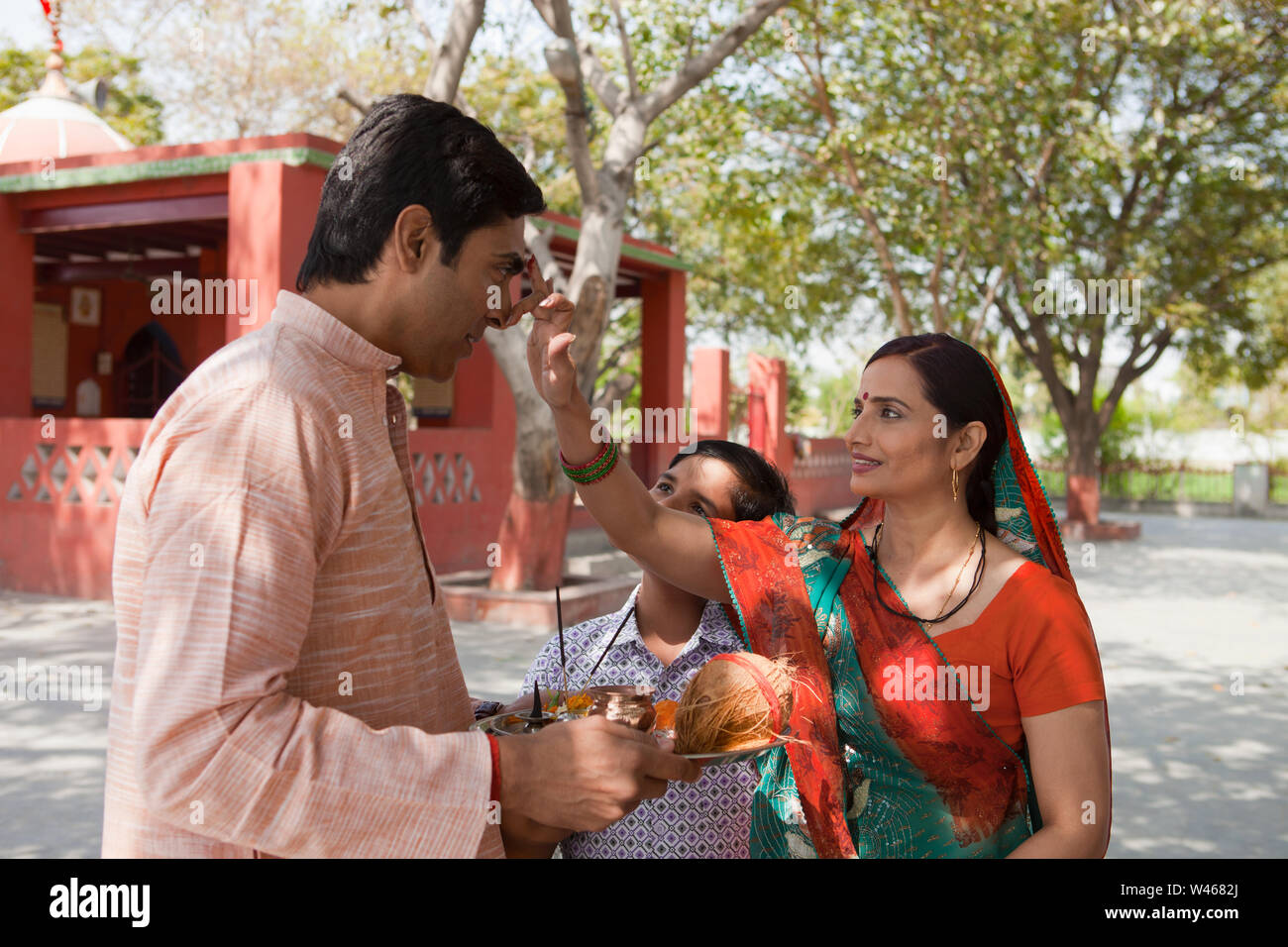 Frau, die tika auf die Stirn ihres Mannes aufträgt Stockfoto