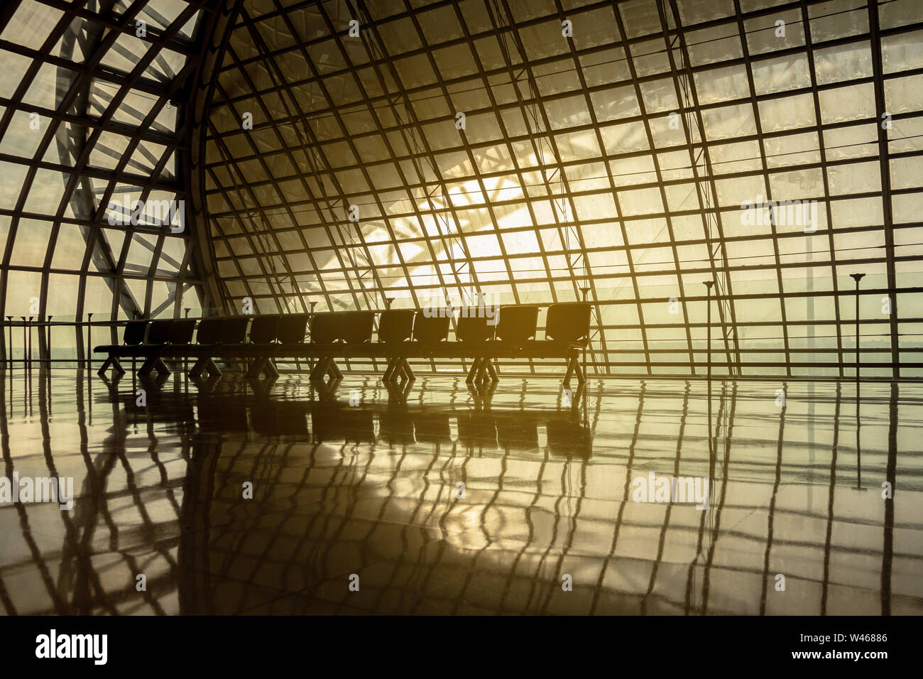Silhouette metall Struktur des modernen Gebäude Architektur und leere Stühle warten mit warmen Sonnenlicht ähnlich wie Raumschiff Interieur. abstrakte Moderne Stockfoto