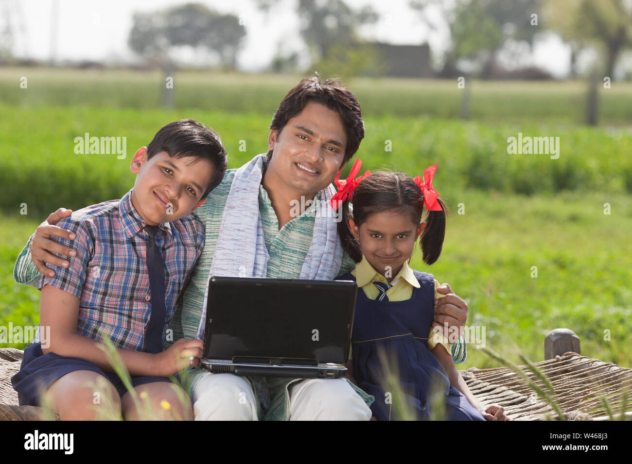 Mann mit Laptop mit seinen Kindern Stockfoto