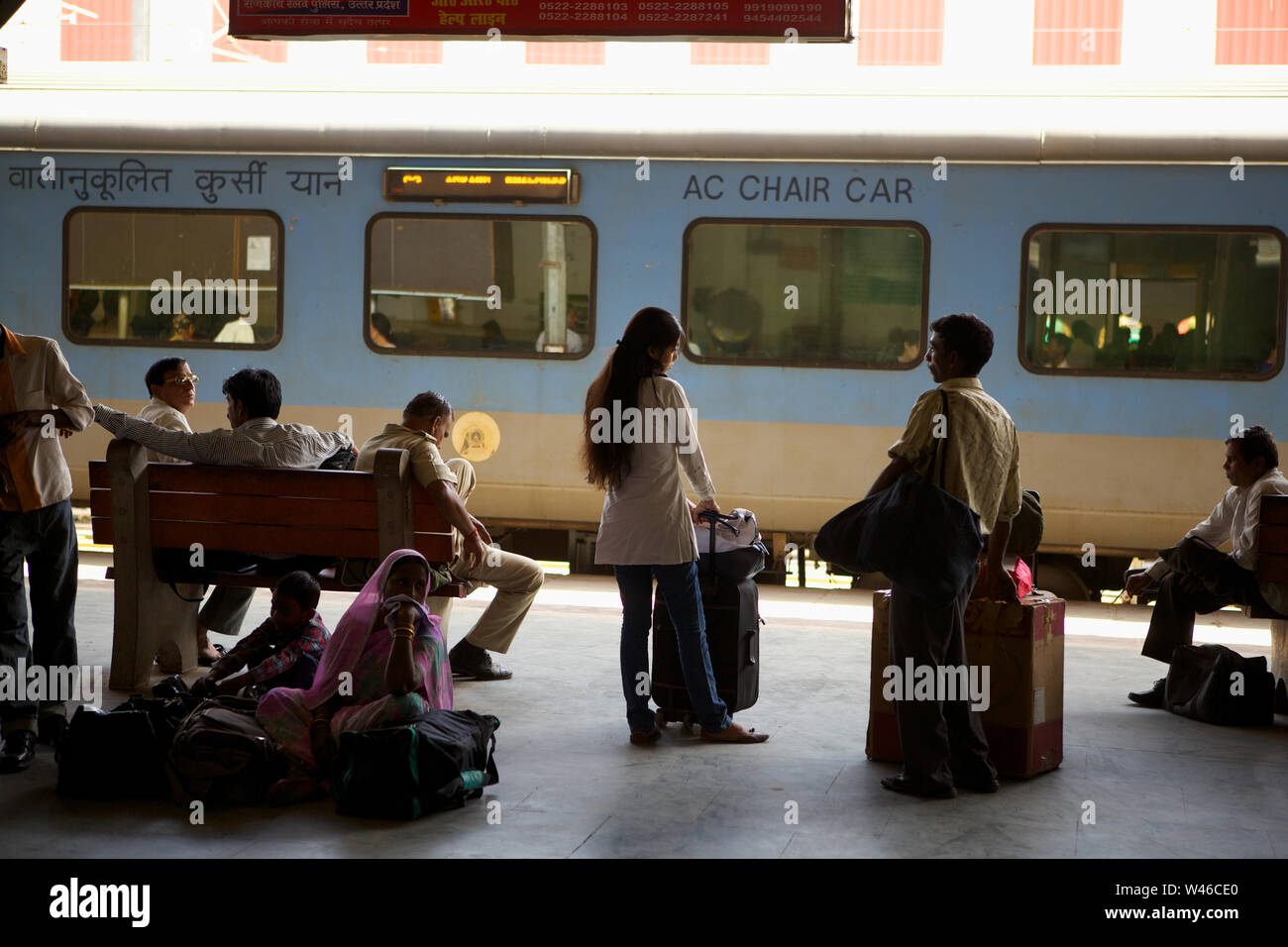 Indische Passagiere warten auf Zug auf einem Bahnsteig Stockfoto