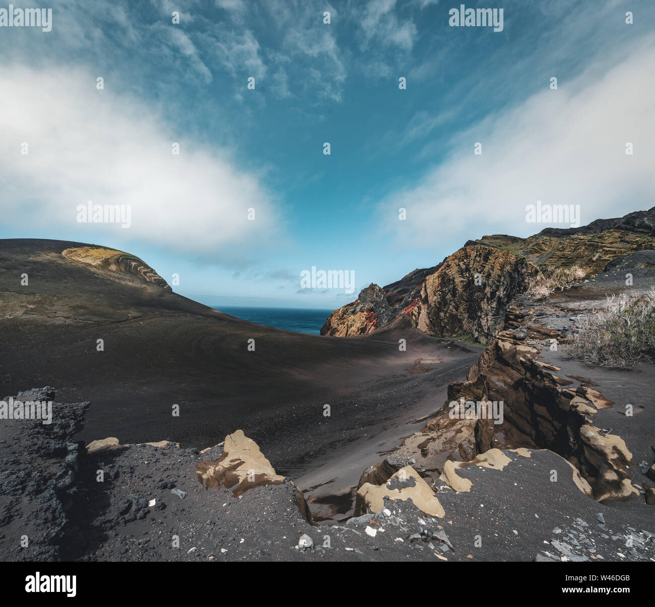 Blick über den Vulkan Capelinhos, Leuchtturm von Ponta Dos Capelinhos auf der westlichen Küste auf die Insel Faial, Azoren, Portugal an einem sonnigen Tag mit blauen Himmel und Stockfoto