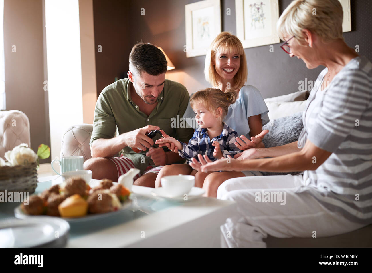 Junge Eltern mit weiblichen Kind besuch Großmutter Stockfoto