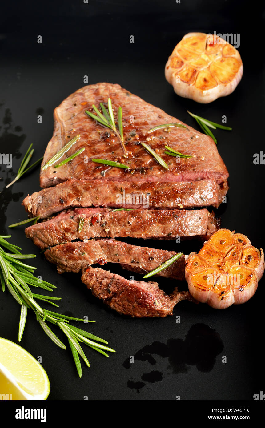 Saftige Steak medium Rindfleisch mit Gewürzen auf dunklem Hintergrund, Ansicht schließen Stockfoto