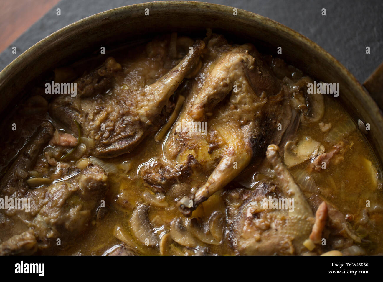 Ein Eintopf aus wilden Wald Tauben, Columba Palumbus, Kochen, Zwiebeln, Speck, Rindfleisch enthält Cannellini Bohnen, in Scheiben geschnittenen Champignons und frischen Ro Stockfoto