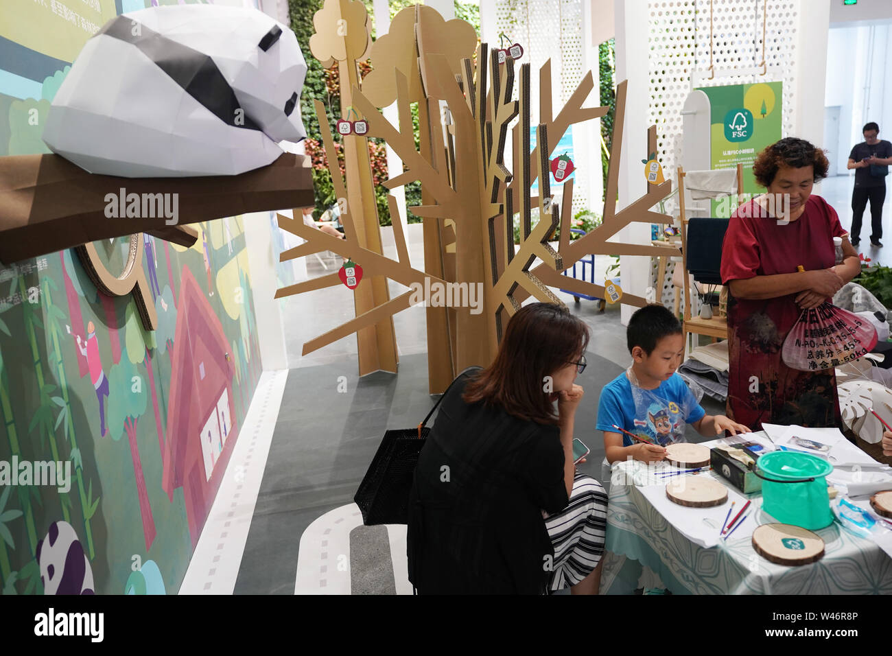 Peking, China. 20. Juli 2019. Ein Junge zieht Gemälde auf der Ausstellungsfläche der Forest Stewardship Council (FSC) FSC während der Veranstaltung der 'Tag' an der Peking Internationale Gartenbauausstellung in Peking, der Hauptstadt von China, 20. Juli 2019. Die 'FSC' Fall wurde an der Peking Internationale Gartenbauausstellung am Samstag statt. Credit: Ju Huanzong/Xinhua/Alamy Leben Nachrichten Quelle: Xinhua/Alamy leben Nachrichten Stockfoto