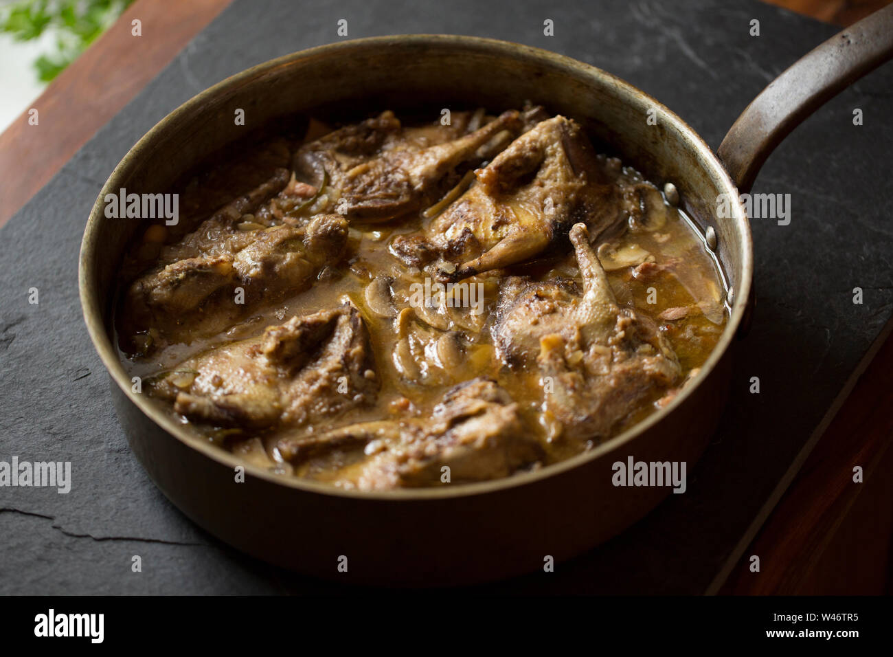 Ein Eintopf aus wilden Wald Tauben, Columba Palumbus, Kochen, Zwiebeln, Speck, Rindfleisch enthält Cannellini Bohnen, in Scheiben geschnittenen Champignons und frischen Ro Stockfoto