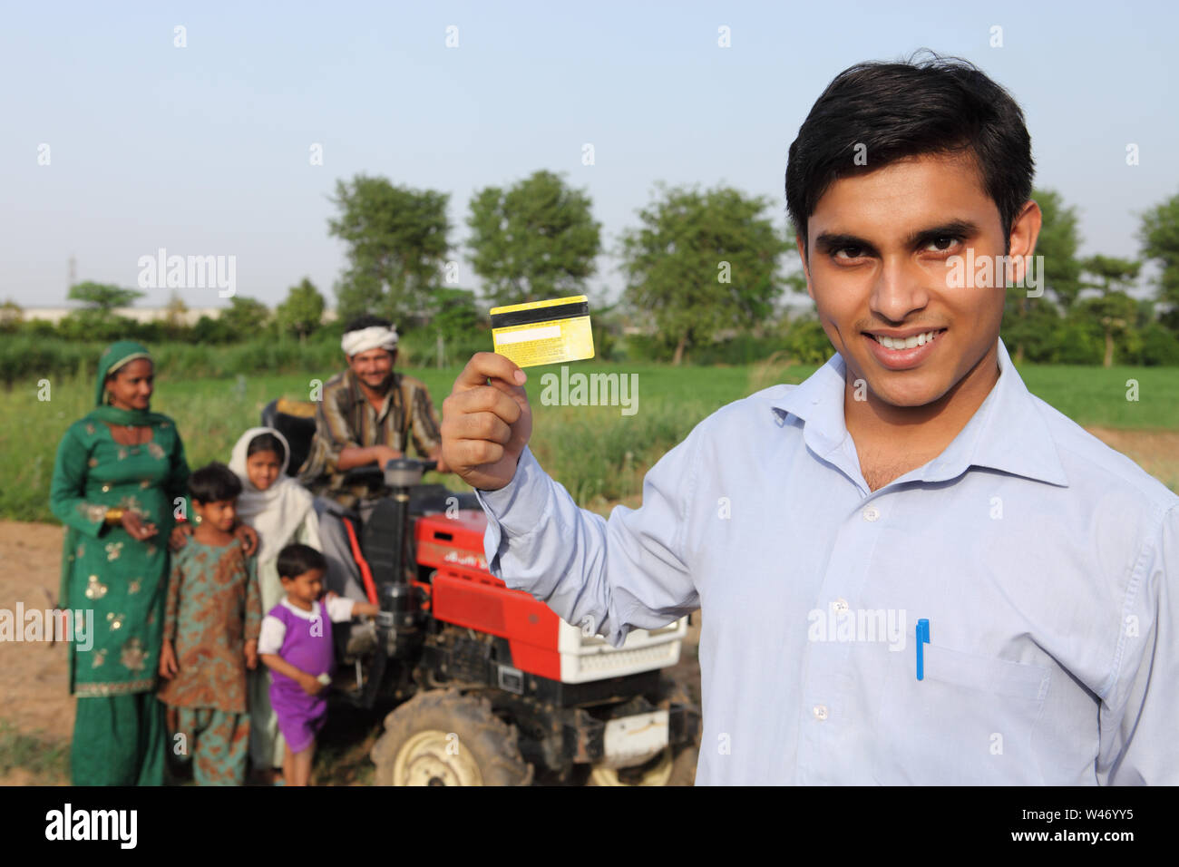 Porträt eines Mannes mit einer Kreditkarte mit einer ländlichen Familie Stockfoto