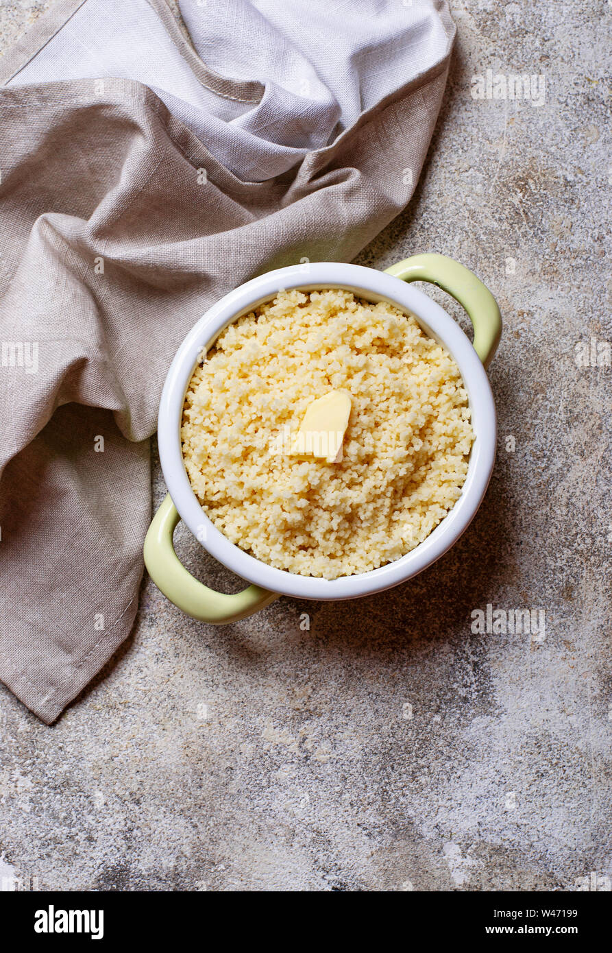 Couscous mit Butter im Topf auf hellen Hintergrund Stockfoto