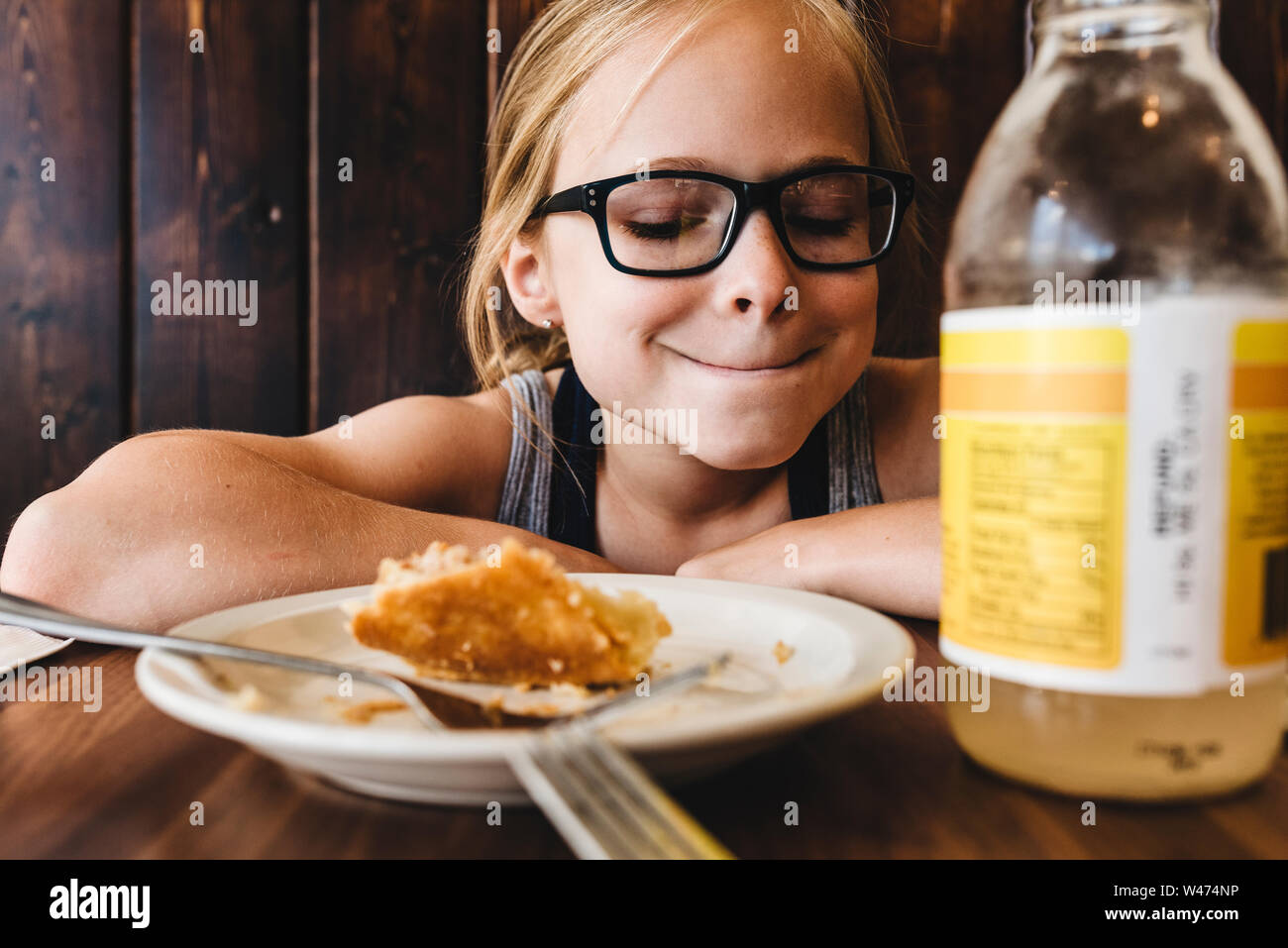 Kleines Mädchen isst und trinkt am Tisch im Cafe Restaurant. Stockfoto