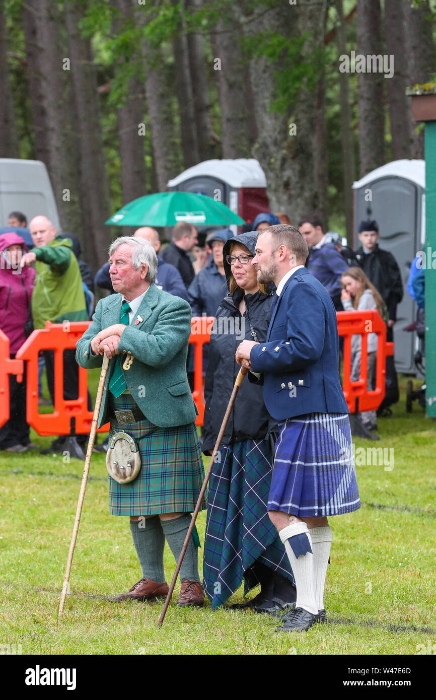 Tomintoul, Schottland. 20. Juli 2019 eines der wichtigsten Highland Games Sammlung begann mit dem traditionellen Umzug der lokalen Pipe Bands durch die Stadt von Tomintoul und bedankte sich bei den Einheimischen an mehreren Haltestellen auf dem Weg, ein dram der lokalen Scotch Whisky zu jedem Mitglied der Bands. Trotz starker Regen, die Spiele weiterhin Unterhaltung auf Tausende von Zuschauern und viele Touristen aus dem Ausland Stockfoto