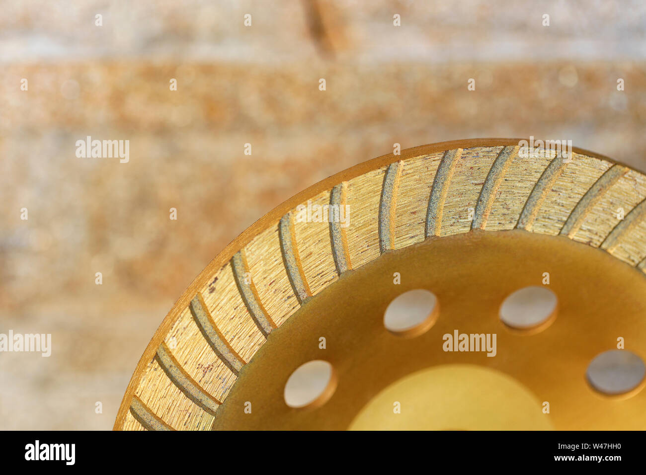 Teil der Diamant Schleifscheibe gegen eine orange-goldene Sandstein Hintergrund close-up. Stockfoto