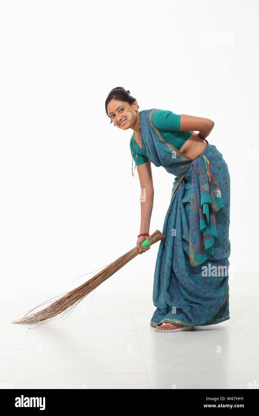 Frau fegt, und lächelnd Stockfoto