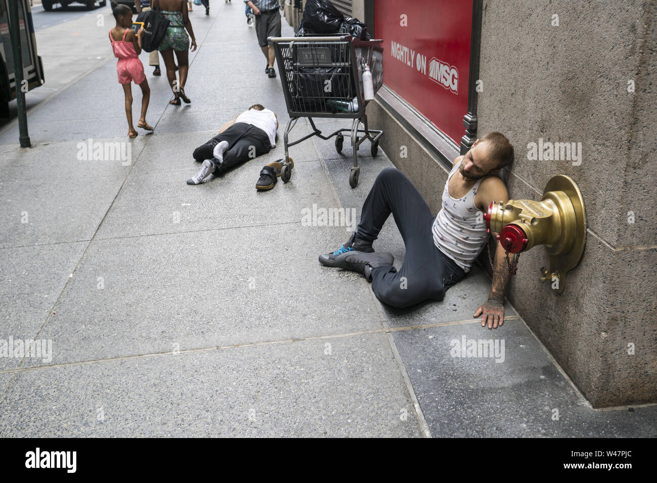 Zwei Männer, die sich an der West 32nd Street in Manhattan, wahrscheinlich aufgrund von Alkoholkonsum in New York City Stockfoto