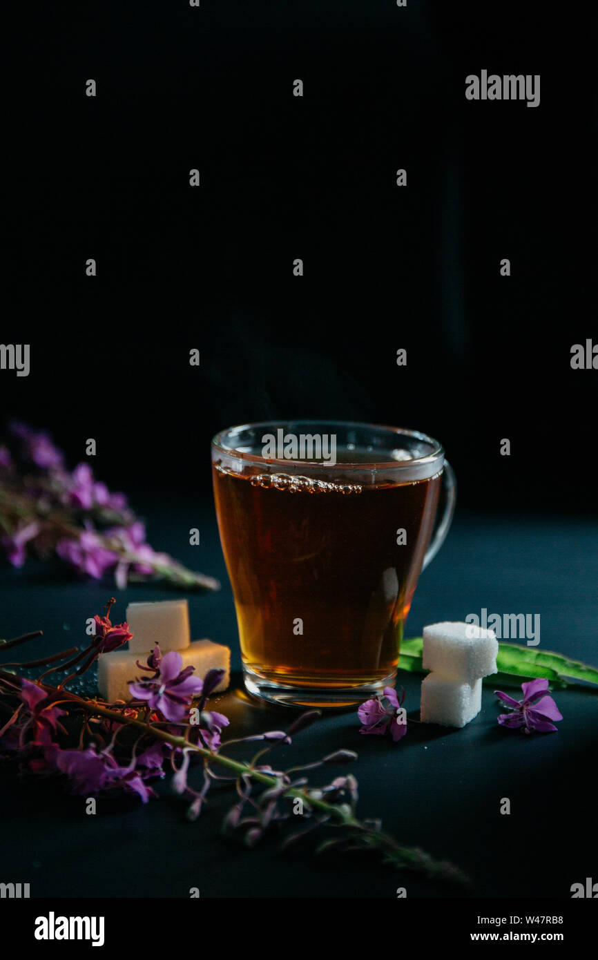 Glas Tasse braunen schwarzen heißen süßen Tee mit Blasen und Spritzer aus geworfen lösen Stück Zucker und zwei Stücke von weißem Zucker. Blühende Sally Stockfoto
