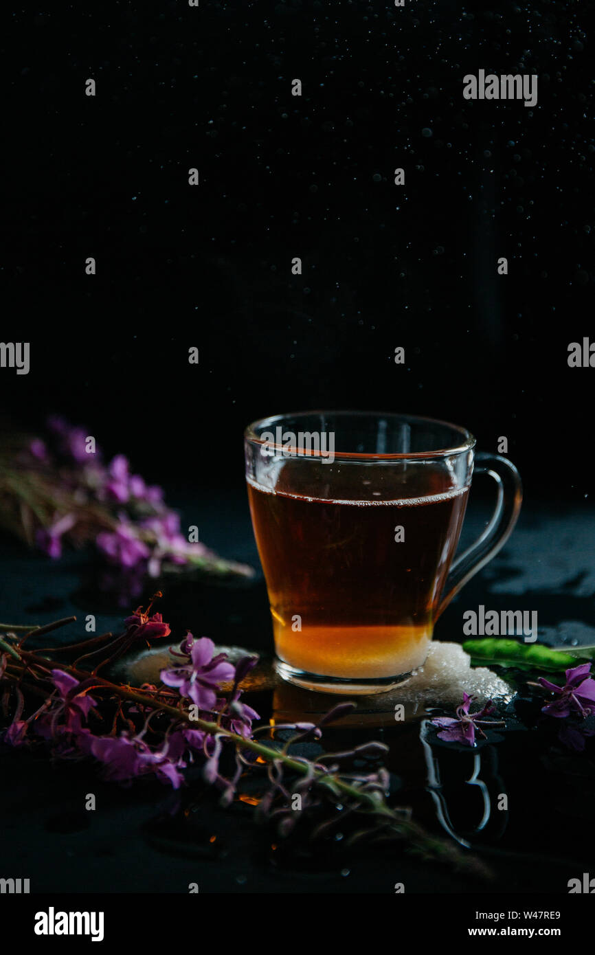 Glas Tasse braunen schwarzen heißen süßen Tee mit Blasen und Spritzer aus geworfen lösen Stück Zucker und zwei Stücke von weißem Zucker. Blühende Sally Stockfoto