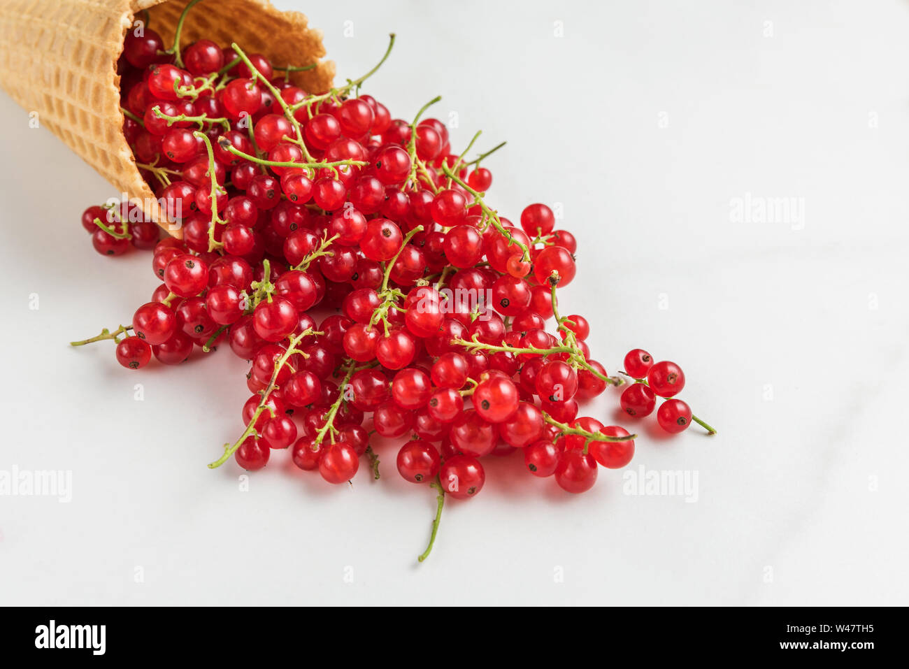 Organische Sommer Beeren rote Johannisbeere in der Waffel Eiswaffel auf weißem Hintergrund. Sommer essen Konzept. Nach oben Schließen Stockfoto