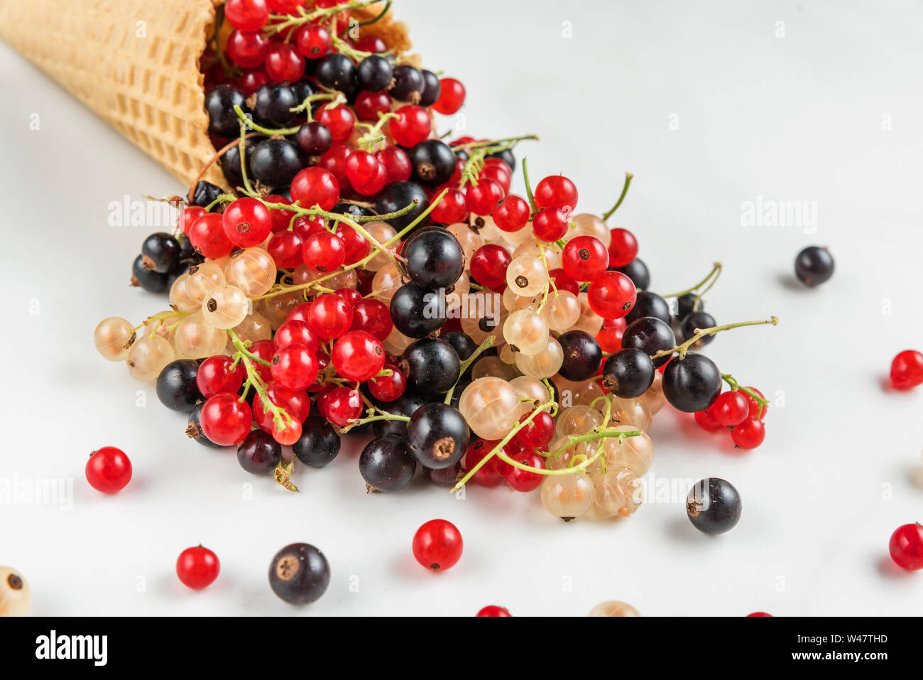 Sortiment von johannisbeere Beeren Schwarz, Rot und Weiß in der Waffel Eiswaffel auf weißem Hintergrund. Sommer essen Konzept. Nach oben Schließen Stockfoto