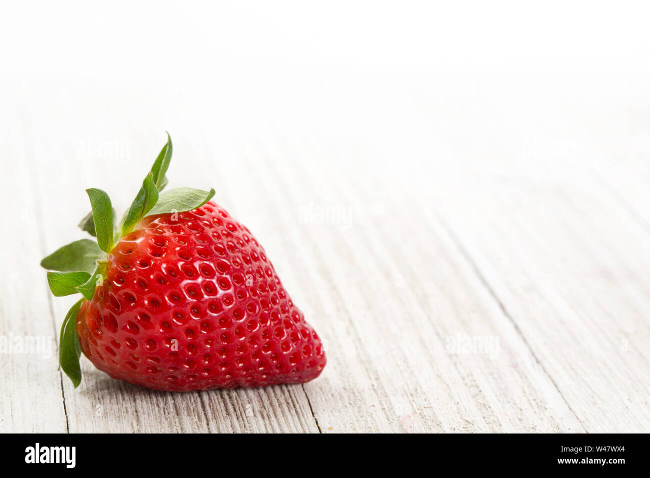 Frische Erdbeeren auf einem weißen Holz Hintergrund Stockfoto