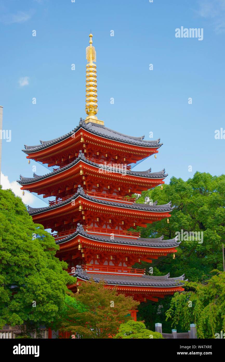 Die hellen Goldenen Turm und leuchtend rote Lackierung von Fukuoka den lebhaften, bunten Pagode (Japan). Blauer Himmel und grünen Bäumen im Hintergrund Stockfoto