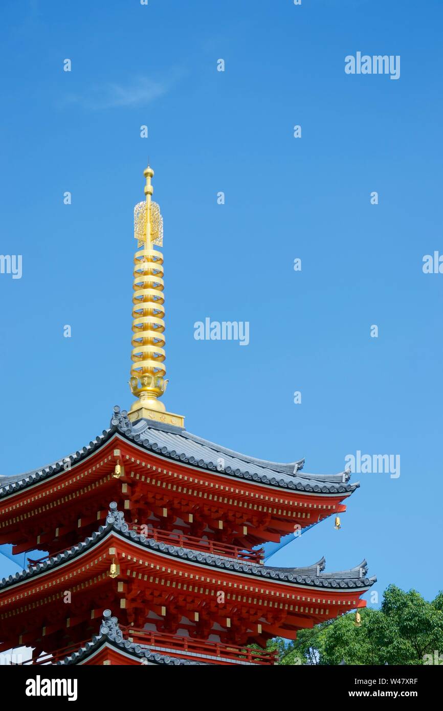 Die hellen Goldenen Turm und leuchtend rote Lackierung von Fukuoka den lebhaften, bunten Pagode (Japan). Blauer Himmel und grünen Bäumen im Hintergrund Stockfoto