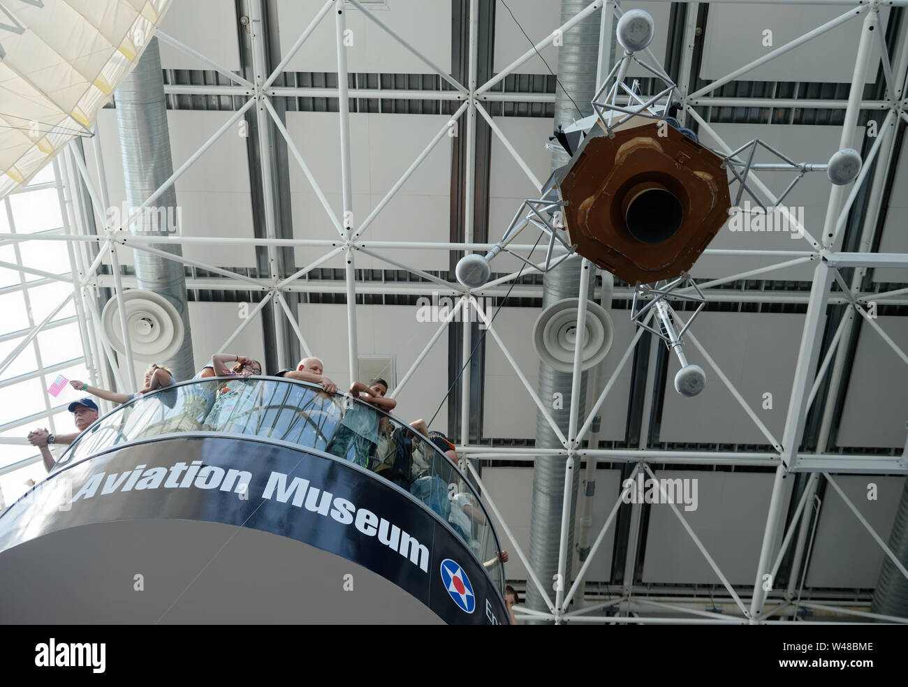 Garden City, New York, USA. 20. Juli 2019. Besucher von hohem Landung auf der 3. Etage Treppe in der Nähe der 1/3 Modell des Apollo 11 Lunar Module der Adler von der Decke abgehängt und bereit, an die genaue Zeit der Apollo 11 Lunar Module, den Adler, auf dem Mond vor 50 Jahren landete abzusteigen, an der Apollo 50 Countdown Feier an der Wiege der Luftfahrt Museum in Long Island. Quelle: Ann Parry/ZUMA Draht/Alamy leben Nachrichten Stockfoto