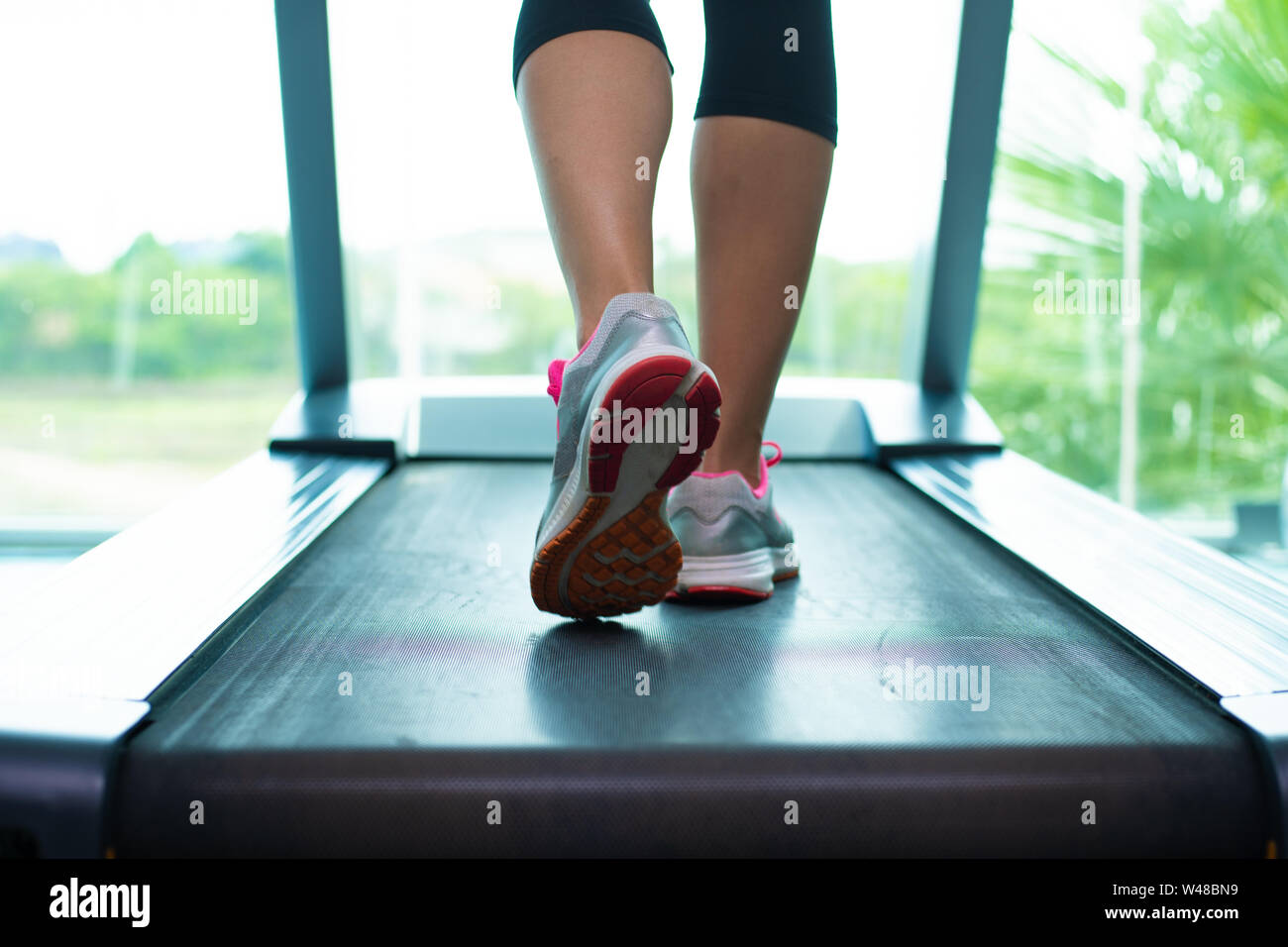 Close up womans Beine in rosa Sneakers auf Ein. Laufband im Fitnessstudio Stockfoto