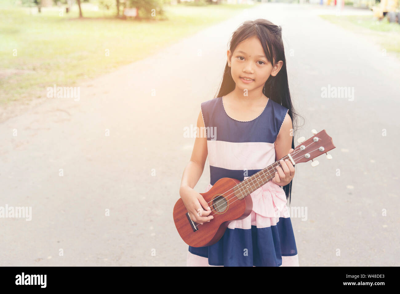 Süßes kleines Kind Mädchen Gitarre zu spielen. Stockfoto