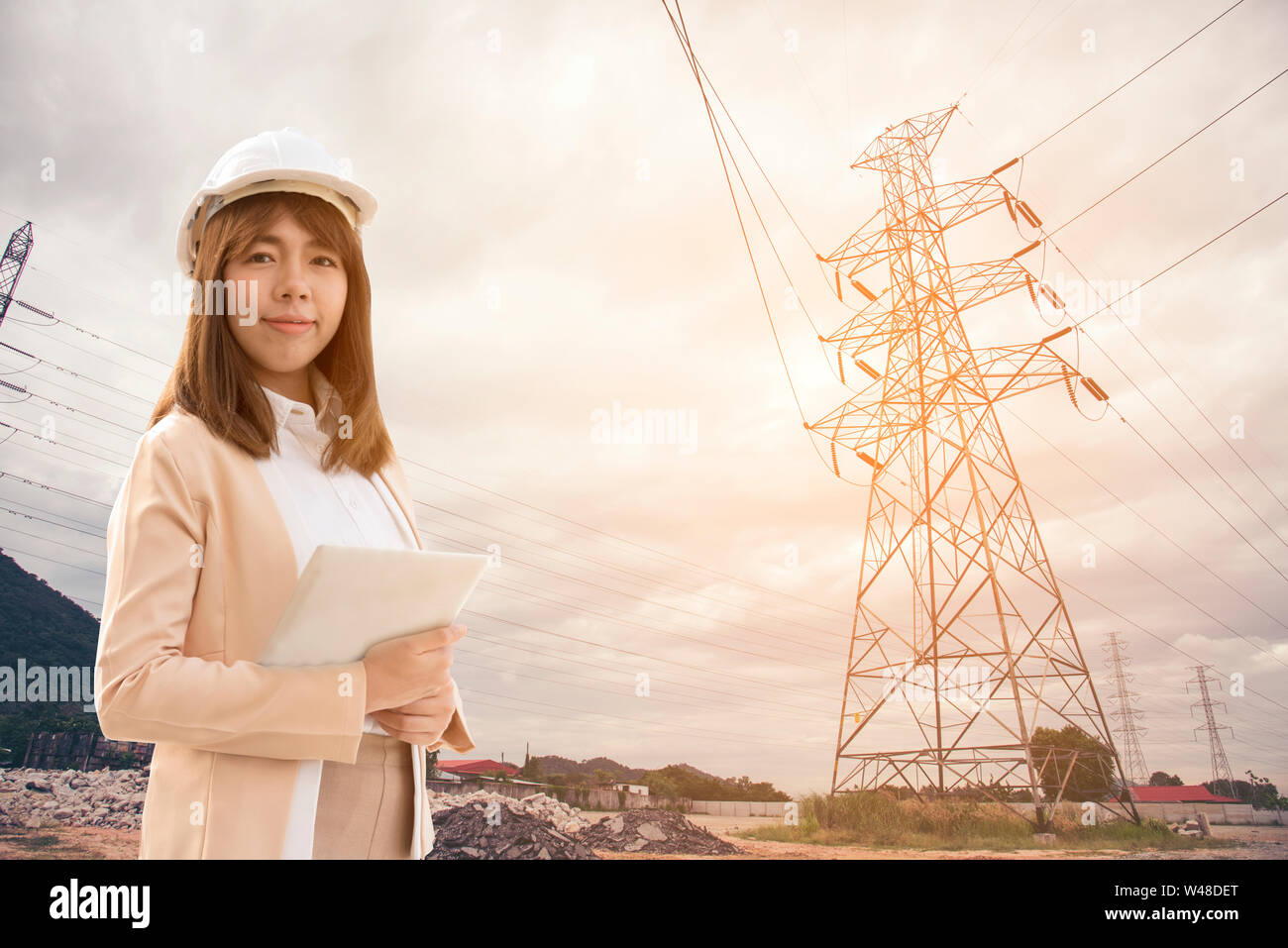 Smart junge schöne Elektroingenieur Frau arbeiten mit Tablet für die Kontrolle der Stromnetze an elektrischen Werk. Stockfoto