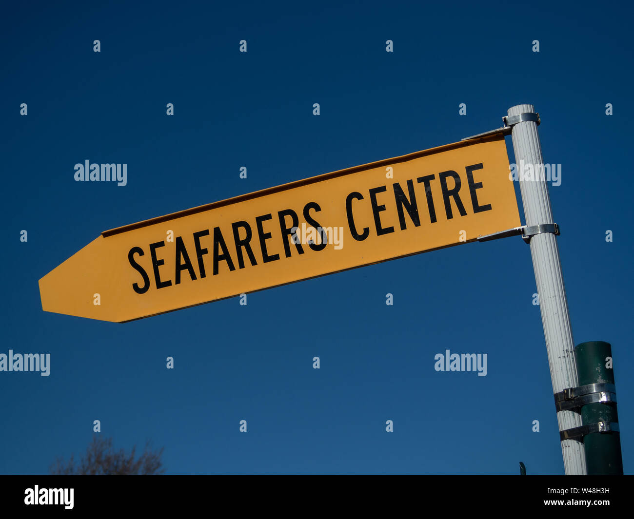 Gelbes Schild mit westlichen Skript liest die eafarers Zentrum', gegen deep blue sky Stockfoto